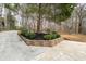 View of the concrete driveway lined with retaining walls and manicured landscaping at 2796 County Line Rd, Acworth, GA 30101