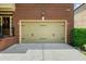 Attached two car garage with light beige doors and black hardware at 3086 Frazier Walk, Decatur, GA 30033