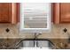 A view of the kitchen sink shows custom tile backsplash, granite counter tops and wood cabinets at 3086 Frazier Walk, Decatur, GA 30033