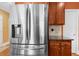 Close up of a stainless steel refrigerator with ice dispenser, wooden cabinets and stainless steel hardware at 3086 Frazier Walk, Decatur, GA 30033
