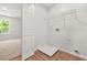 A well-lit laundry room with wood-look flooring, featuring wire shelving, and space for laundry appliances at 3454 Carriage Chase Rd, Atlanta, GA 30349