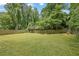 Large, grassy backyard with a wood fence and mature trees at 1585 Melanie Ct, Decatur, GA 30032