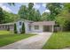 Charming home with a long driveway and a carport, surrounded by lush greenery and a well-manicured lawn at 1585 Melanie Ct, Decatur, GA 30032