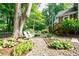 Charming backyard with stone pathways, lush plantings, and a serene seating area beneath a mature tree at 3620 Chartwell Dr, Suwanee, GA 30024