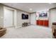 Finished basement with a mounted TV, red cabinets, neutral color walls, and carpeted floors at 3620 Chartwell Dr, Suwanee, GA 30024