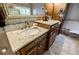 Bathroom featuring double vanities with stone countertops and wood cabinets at 3620 Chartwell Dr, Suwanee, GA 30024