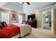 Bedroom featuring tray ceilings, a TV, and doorway to other areas of the house at 3620 Chartwell Dr, Suwanee, GA 30024