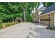 Spacious driveway leading to the side of a home with lush landscaping at 3620 Chartwell Dr, Suwanee, GA 30024