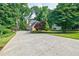 Long concrete driveway leading to a home surrounded by lush greenery and trees at 3620 Chartwell Dr, Suwanee, GA 30024