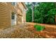 Home exterior featuring a two-car garage, stone pathway, landscaping, and wooded area at 3620 Chartwell Dr, Suwanee, GA 30024