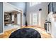Bright foyer featuring hardwood floors, a striking black rug, and adjacent office space at 3620 Chartwell Dr, Suwanee, GA 30024
