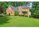 Beautiful brick home featuring a large front yard with mature trees and shrubs at 3620 Chartwell Dr, Suwanee, GA 30024
