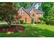 Charming brick home with lush landscaping and a well-manicured lawn at 3620 Chartwell Dr, Suwanee, GA 30024