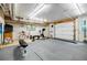 Spacious garage featuring gym equipment, rubber floors, a garage door, and exposed duct work at 3620 Chartwell Dr, Suwanee, GA 30024