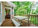 Charming outdoor deck with dining table and seating, surrounded by lush greenery, perfect for outdoor entertaining at 3620 Chartwell Dr, Suwanee, GA 30024