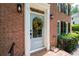 Inviting brick home featuring a decorative front door, manicured greenery, and stylish exterior lighting at 4429 Windsor Oaks Cir, Marietta, GA 30066