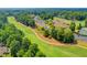 Aerial view of a golf course, club house, and tennis courts surrounded by mature trees at 3070 Ascot Ln, Roswell, GA 30076