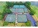 Aerial view of tennis courts surrounded by trees in a golf course community at 3070 Ascot Ln, Roswell, GA 30076