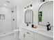 Bathroom featuring double sinks, modern lighting, a shower, and sleek white tiling at 4745 Elam Forest Dr, Stone Mountain, GA 30083