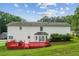 Expansive backyard view featuring a red deck, well-maintained lawn, and mature trees at 1624 Glenfield Dr, Lawrenceville, GA 30043