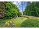 Secluded backyard with manicured bushes, mature trees, and a cozy fire pit area at 1624 Glenfield Dr, Lawrenceville, GA 30043