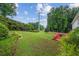 Sprawling backyard with a manicured lawn, mature trees, and a red deck at 1624 Glenfield Dr, Lawrenceville, GA 30043