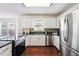 This kitchen features white cabinets, stainless steel appliances, granite countertops and hardwood floors at 1624 Glenfield Dr, Lawrenceville, GA 30043