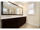 Bathroom with granite countertops, dark cabinets, and large mirror over double sinks at 169 Waterman Se St, Marietta, GA 30060