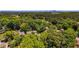 Wide aerial shot showcasing homes nestled amongst dense, mature trees with a city skyline in the background at 1834 Broad Ave, Atlanta, GA 30344