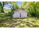 A vintage garage has aged white paint and a pair of barn doors surrounded by mature trees at 1834 Broad Ave, Atlanta, GA 30344