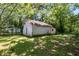 A vintage garage has aged white paint surrounded by mature trees at 1834 Broad Ave, Atlanta, GA 30344