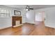 Bright living room with brick fireplace, ceiling fan, hardwood floors, and open doorway at 1834 Broad Ave, Atlanta, GA 30344