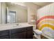 Bright bathroom featuring a vanity, a large mirror, and a rainbow shower curtain at 2039 Wildflower Nw Way, Conyers, GA 30012