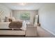 Inviting bedroom featuring a large bed with plush bedding, complementing chairs, and a bright window at 2039 Wildflower Nw Way, Conyers, GA 30012