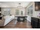 Open-concept dining area next to the living room, featuring dark wood floors, a large table and natural light at 2039 Wildflower Nw Way, Conyers, GA 30012