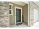 View of the front door and porch area, accented by brickwork and neutral siding at 2039 Wildflower Nw Way, Conyers, GA 30012
