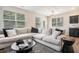 Bright living room featuring a comfortable sectional sofa and views of the well-manicured outdoors at 2039 Wildflower Nw Way, Conyers, GA 30012