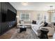 Modern living room with stylish wood accent wall, plush sofa, and ample natural light from large windows at 2039 Wildflower Nw Way, Conyers, GA 30012