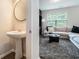 Open-concept living room showcasing a comfortable couch, rug and a half bath with a pedestal sink for added convenience at 2039 Wildflower Nw Way, Conyers, GA 30012