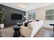 Elegant living room with a cozy sofa, modern accent wall, and lots of natural light at 2039 Wildflower Nw Way, Conyers, GA 30012