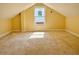 Large attic room with neutral carpeting, yellow walls and a window at 2437 N Decatur Rd, Decatur, GA 30033