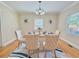 Elegant dining room with hardwood floors, stylish light fixture, and six upholstered chairs at 2437 N Decatur Rd, Decatur, GA 30033