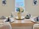 A beautifully staged dining table set with elegant white plates and folded gray napkins at 2437 N Decatur Rd, Decatur, GA 30033
