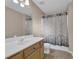 This is a full bathroom with a tile floor, wood vanity, white countertop, shower and tub combination at 5040 Stonehaven Vw, Cumming, GA 30040