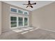 Bright bedroom with tall windows providing ample natural light and views of the surrounding greenery at 5040 Stonehaven Vw, Cumming, GA 30040