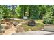 Grassy backyard featuring mature trees, play structures, and storage sheds at 919 Rock Oak Ln, Lawrenceville, GA 30046
