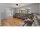 Bright living room featuring hardwood floors, a ceiling fan, and large windows at 919 Rock Oak Ln, Lawrenceville, GA 30046