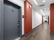 Well-lit hallway featuring wood flooring, red accents, and clearly marked apartment numbers for easy navigation within the building at 112 Rogers Street Ne # 410, Atlanta, GA 30317