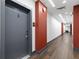 Well-lit hallway with wood floors and contrasting red accents, leading to apartment entrance at 112 Rogers Street Northeast Ne St # 410, Atlanta, GA 30317
