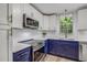 Bright kitchen with white cabinets, navy island, stainless appliances, and wood floors at 2572 Bates Se St, Smyrna, GA 30080